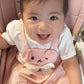 Real customer photo: a happy baby wearing the Little Haven Bunny Buddy Pinafore Dress, shared on Instagram by a parent